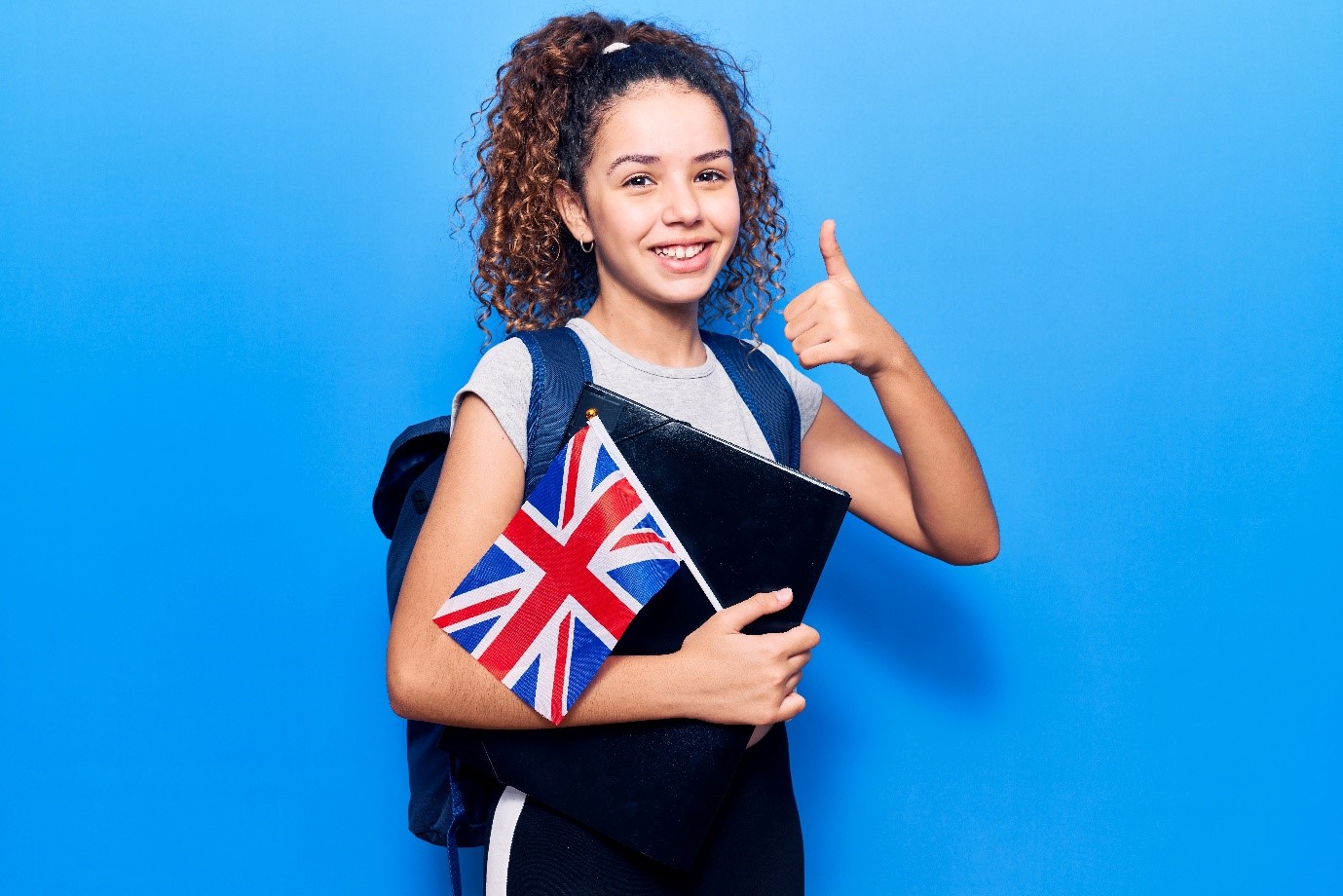 A person with a Union Jack giving a thumbs up