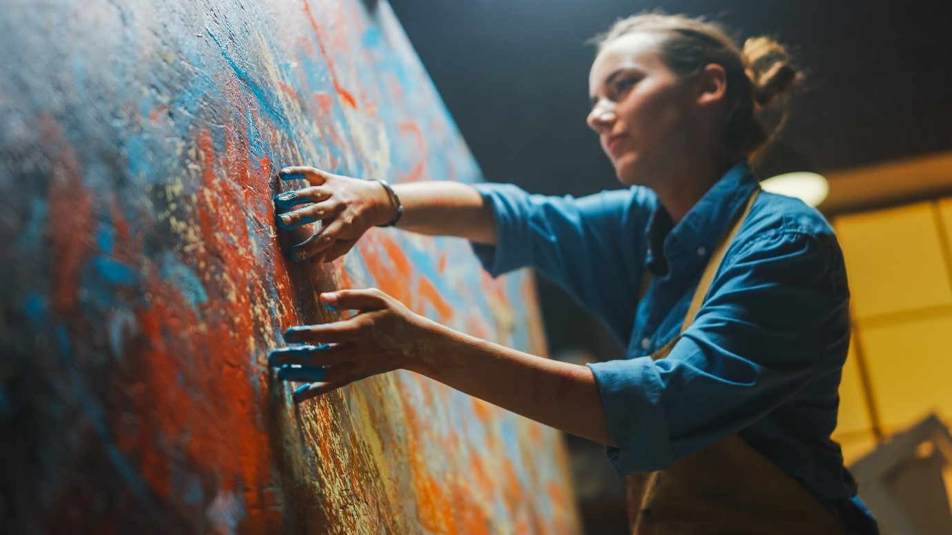 A person in a blue shirt scraping a wall