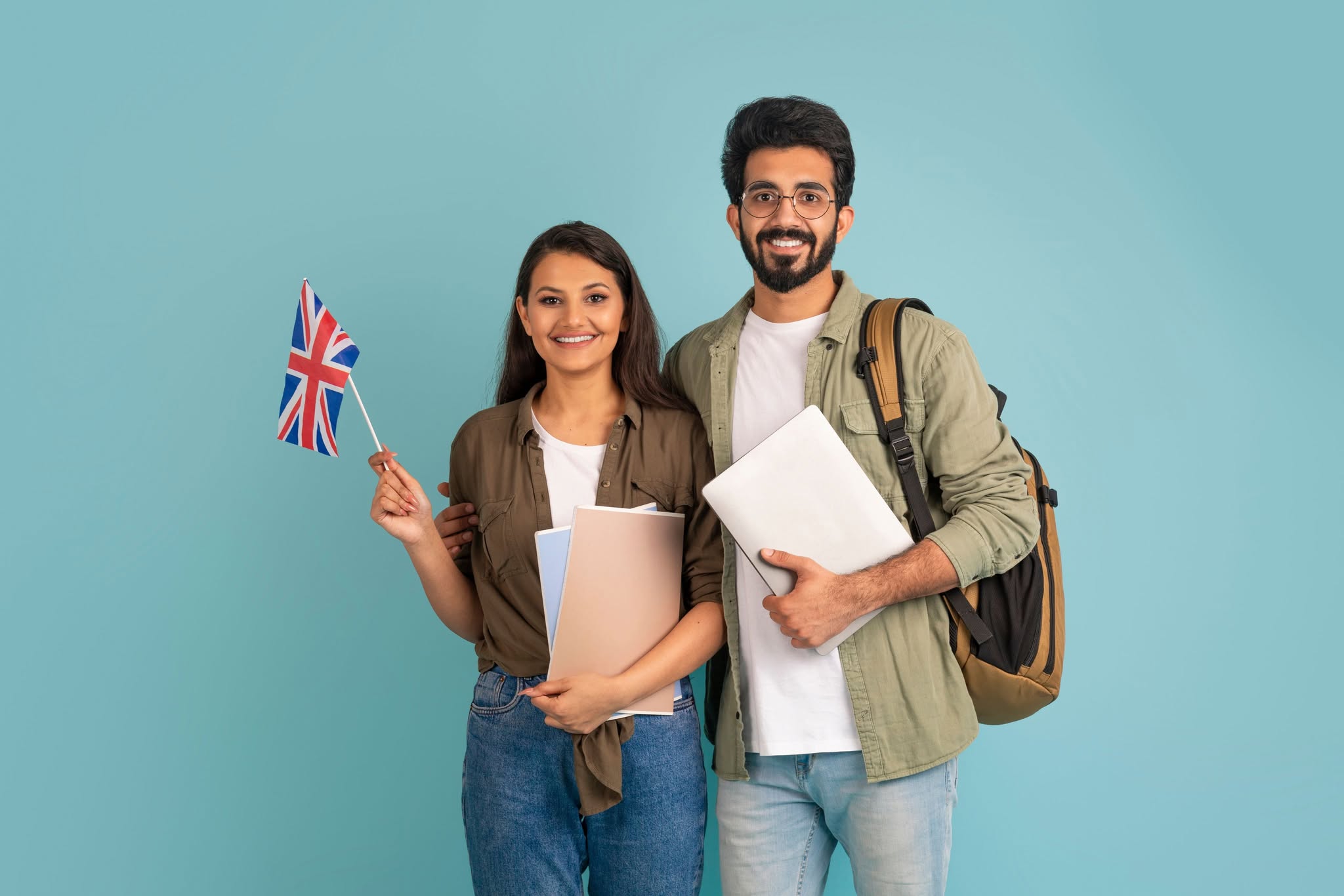 Two people stood with documents and laptops and a UK flag