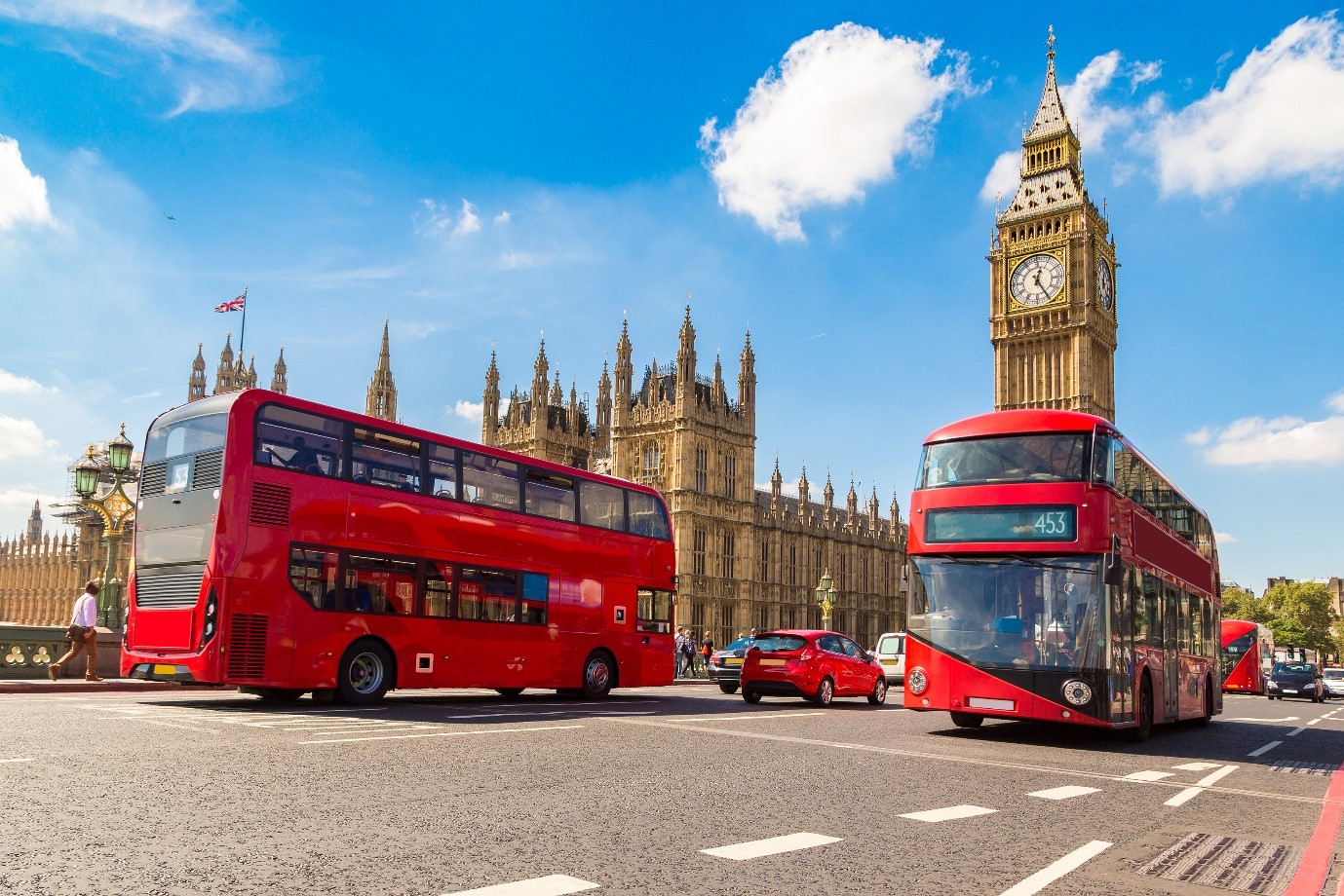 Red London buses in front of the houses of Parliament and Big Ben