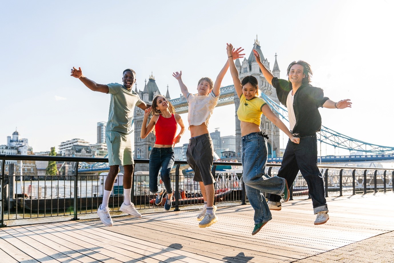 People jumping for joy in front of Tower Bridge London